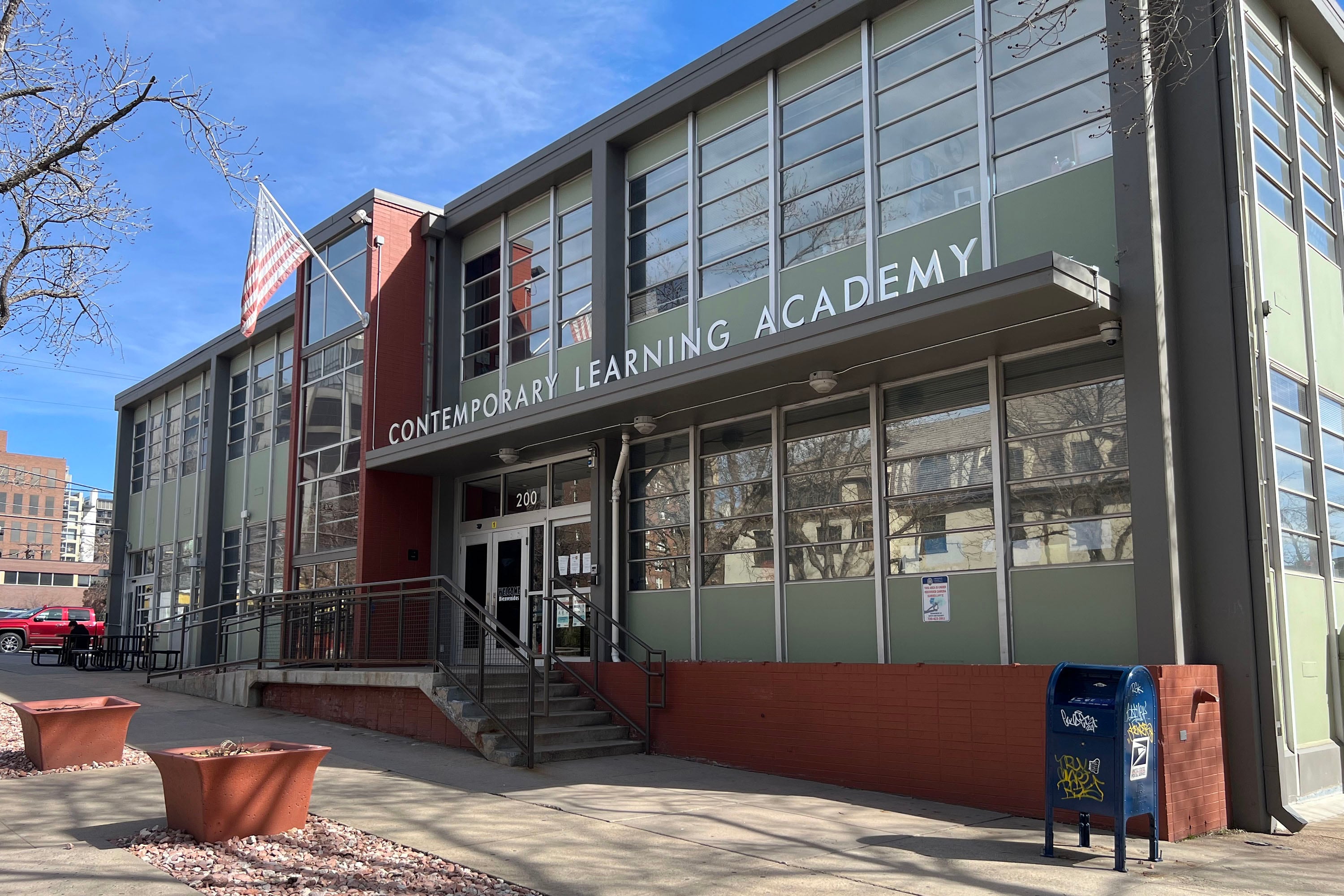 A large school building outside with a blue sky in the background.