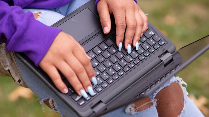 Close-up of a student’s hands typing on a laptop.