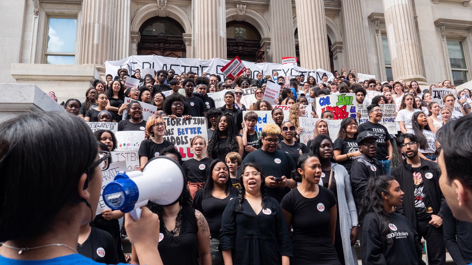 Tiffani Torres holds a megaphone at a recent rally to protest school segregation at the education department's headquarters.