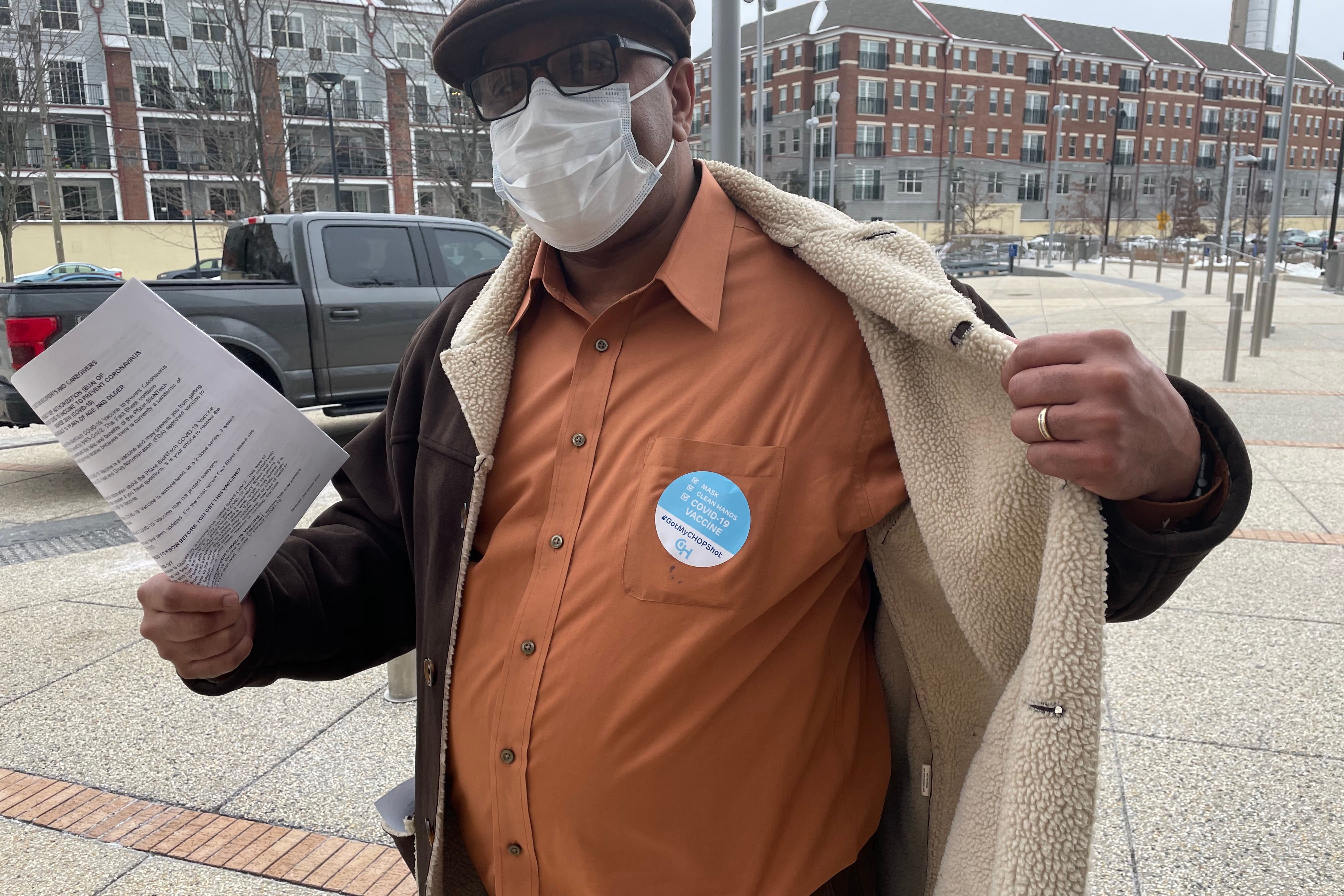 Keith Arrington, principal at John F. Hartranft Elementary School, wearing a face mask and showing off his sticker for taking the vaccine shot.