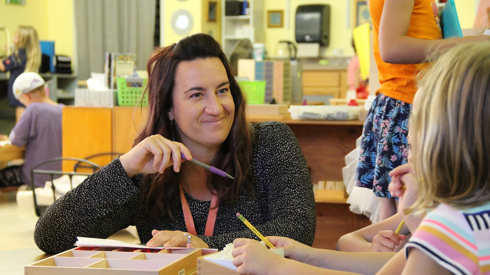 Megan Witucki, a teacher at Compass Montessori School in Wheat Ridge, works with students.