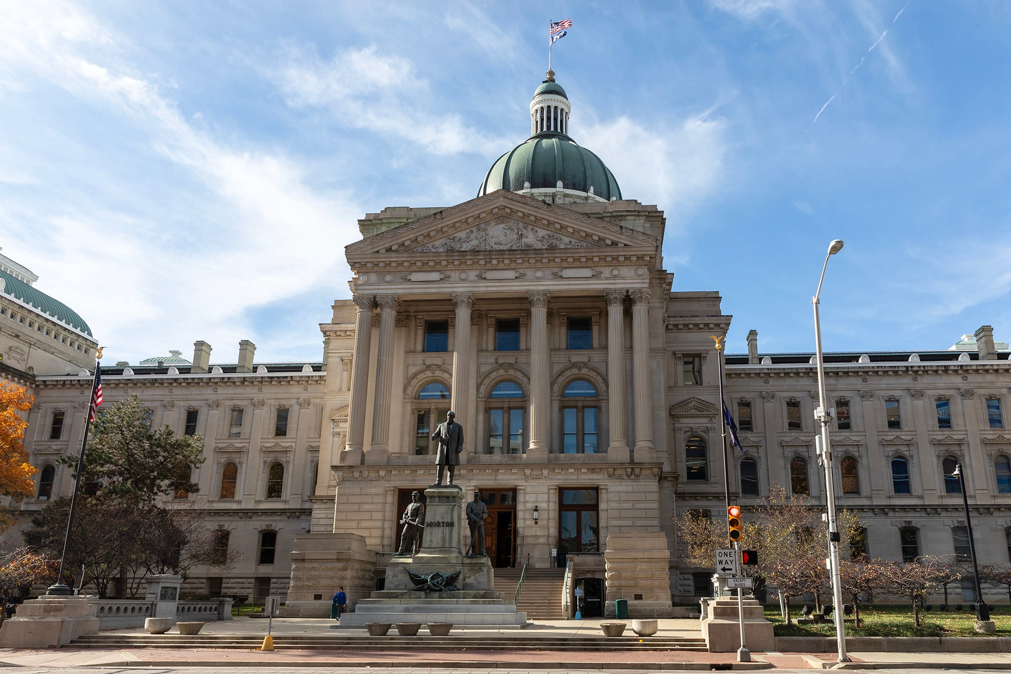 A large stone capital building outside with a blue sky.