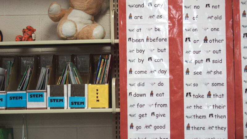 Word chart in a school library. The shelf also has science resources and a stuffed koala bear