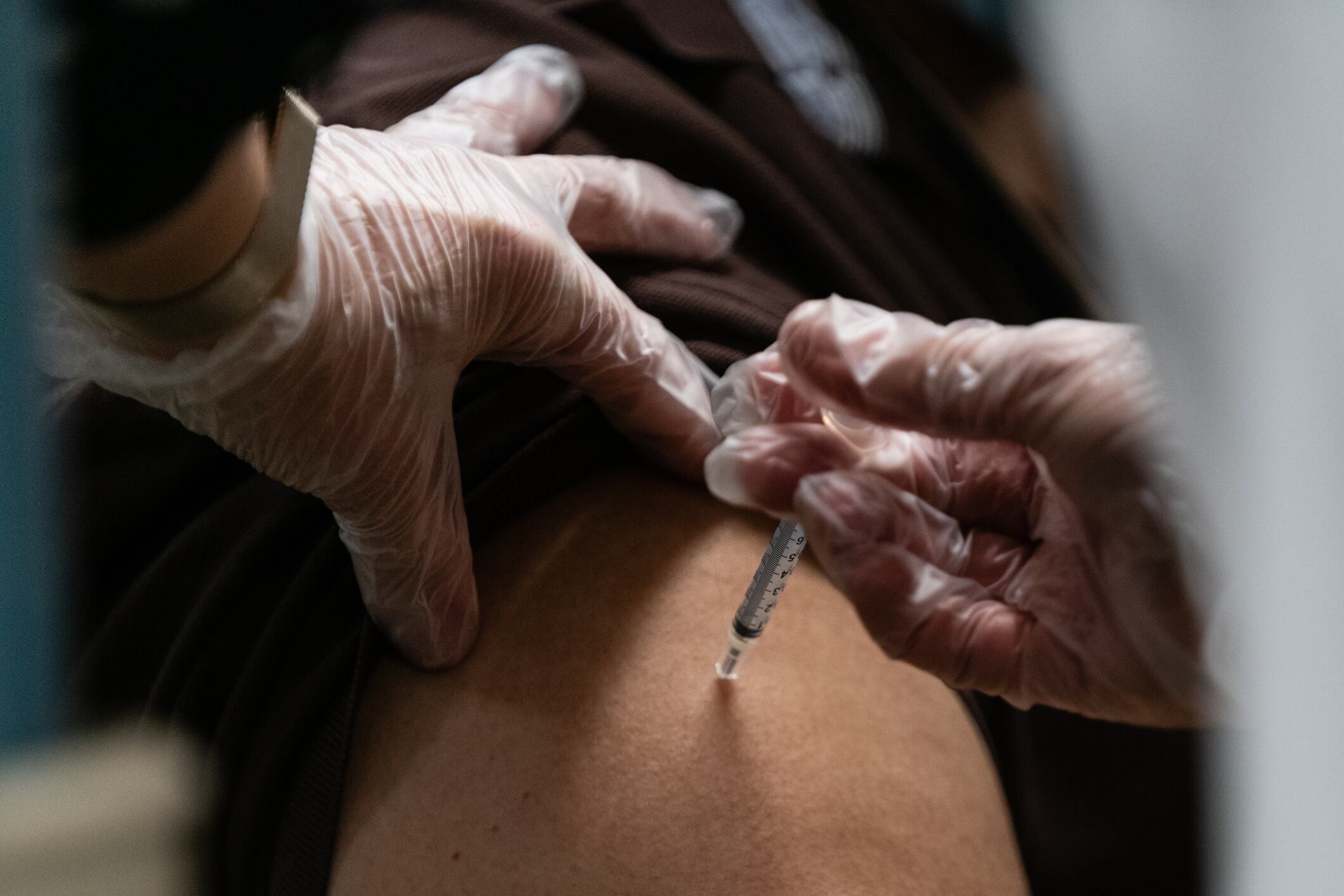 A healthcare worker gives a dose of the COVID vaccine to a patient.