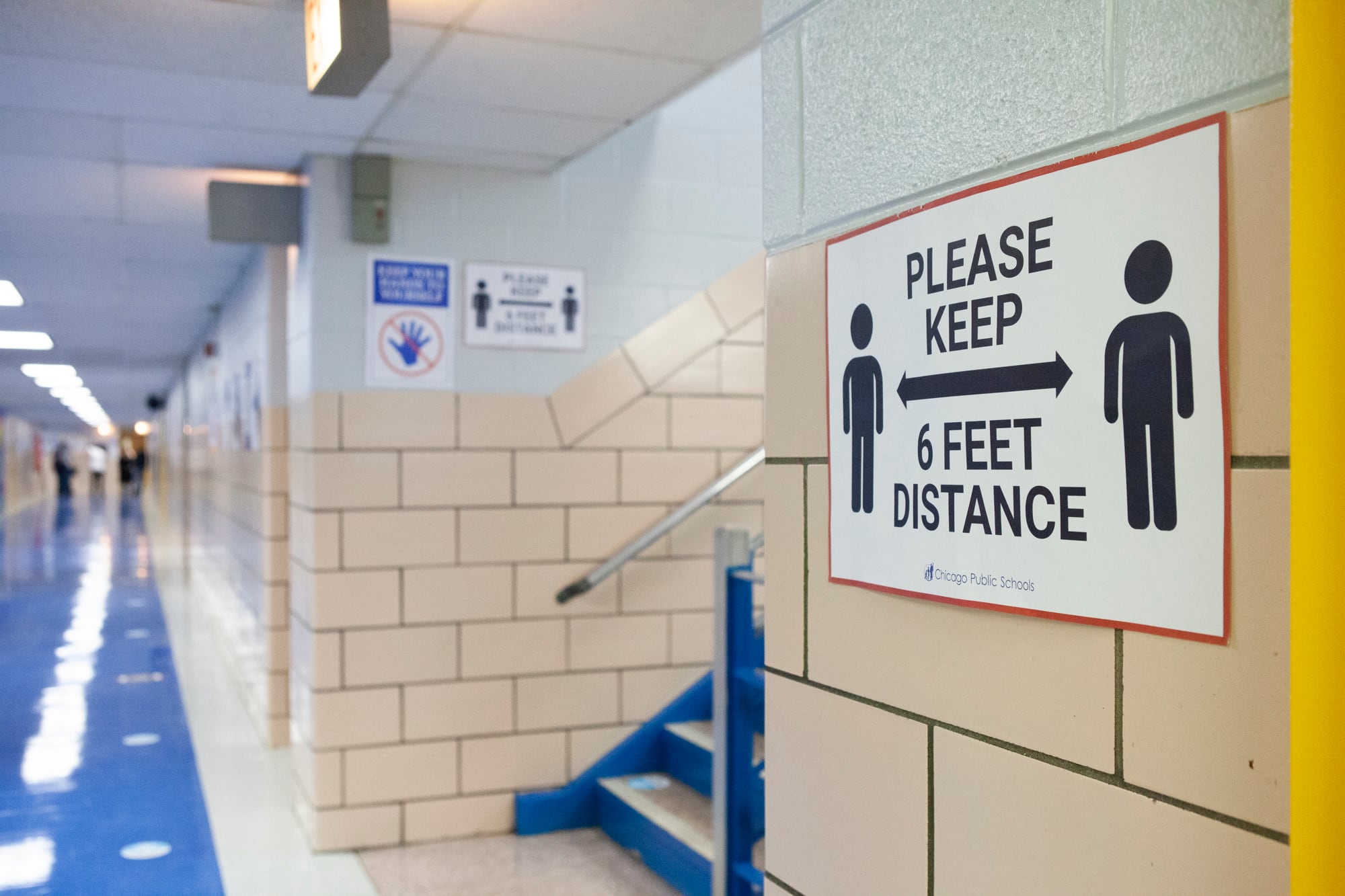 A sign in a school hallway reminding students to keep 6 feet distance apart.
