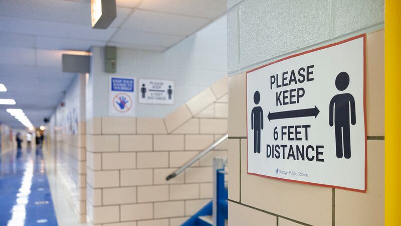 A sign in a school hallway reminding students to keep 6 feet distance apart.