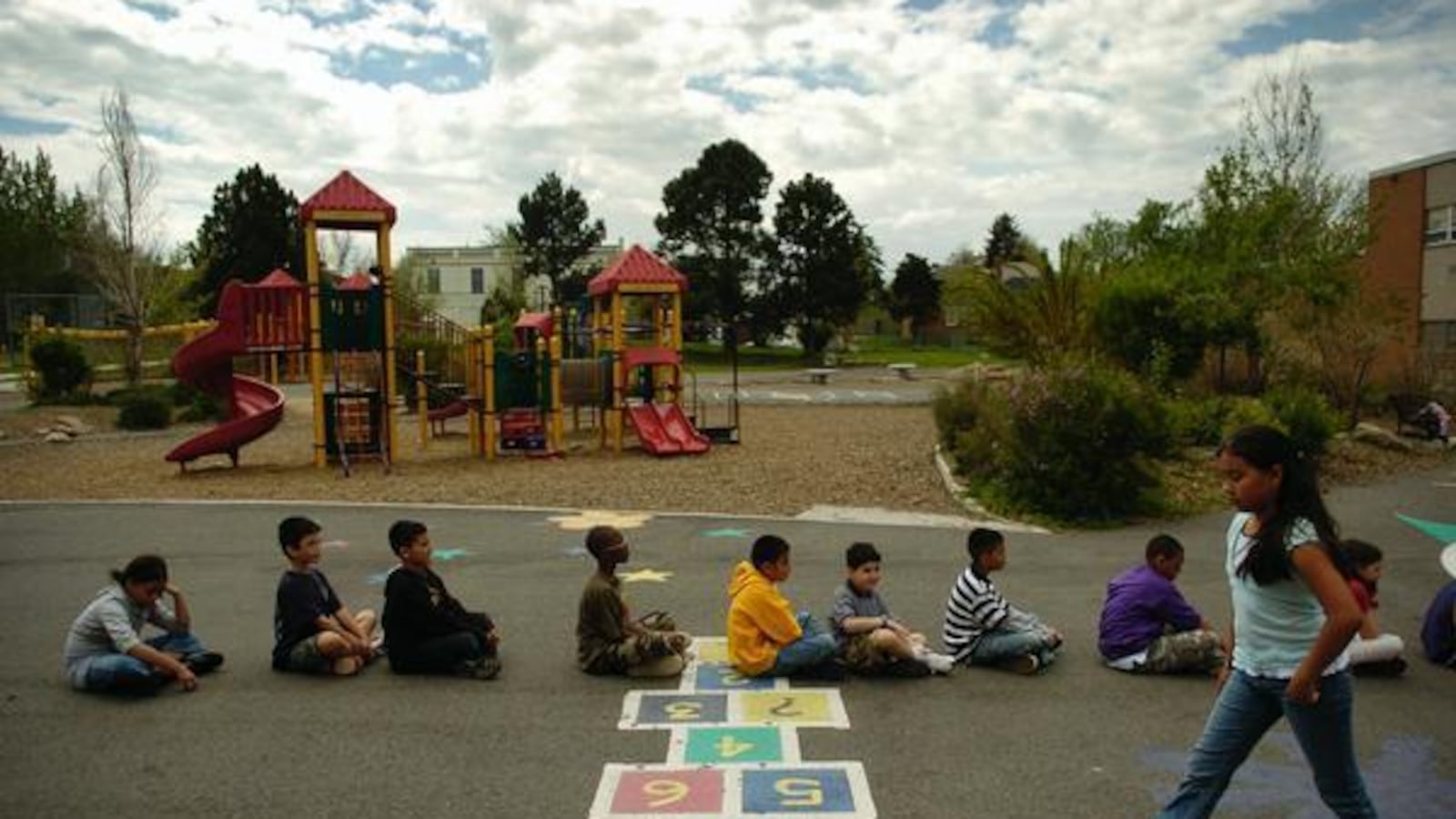 Fourth-graders at Whittier ECE-8 School sit in a line on the playground.
