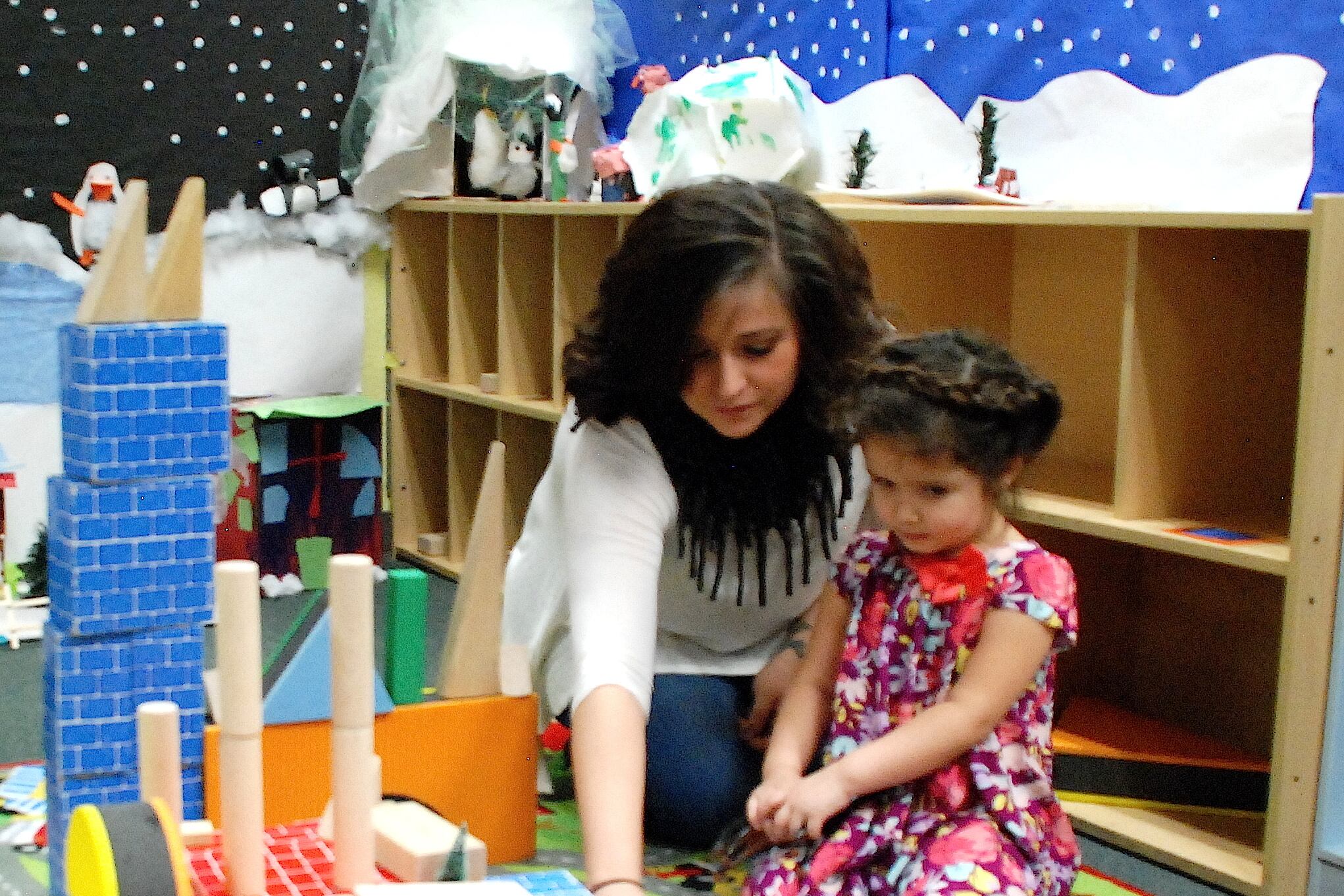 Teacher Rosa Figueroa plays with a child at the Early Excellence Program of Denver.