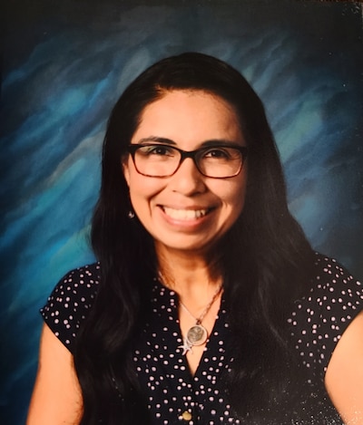 A portrait of a woman with dark hair and glasses.