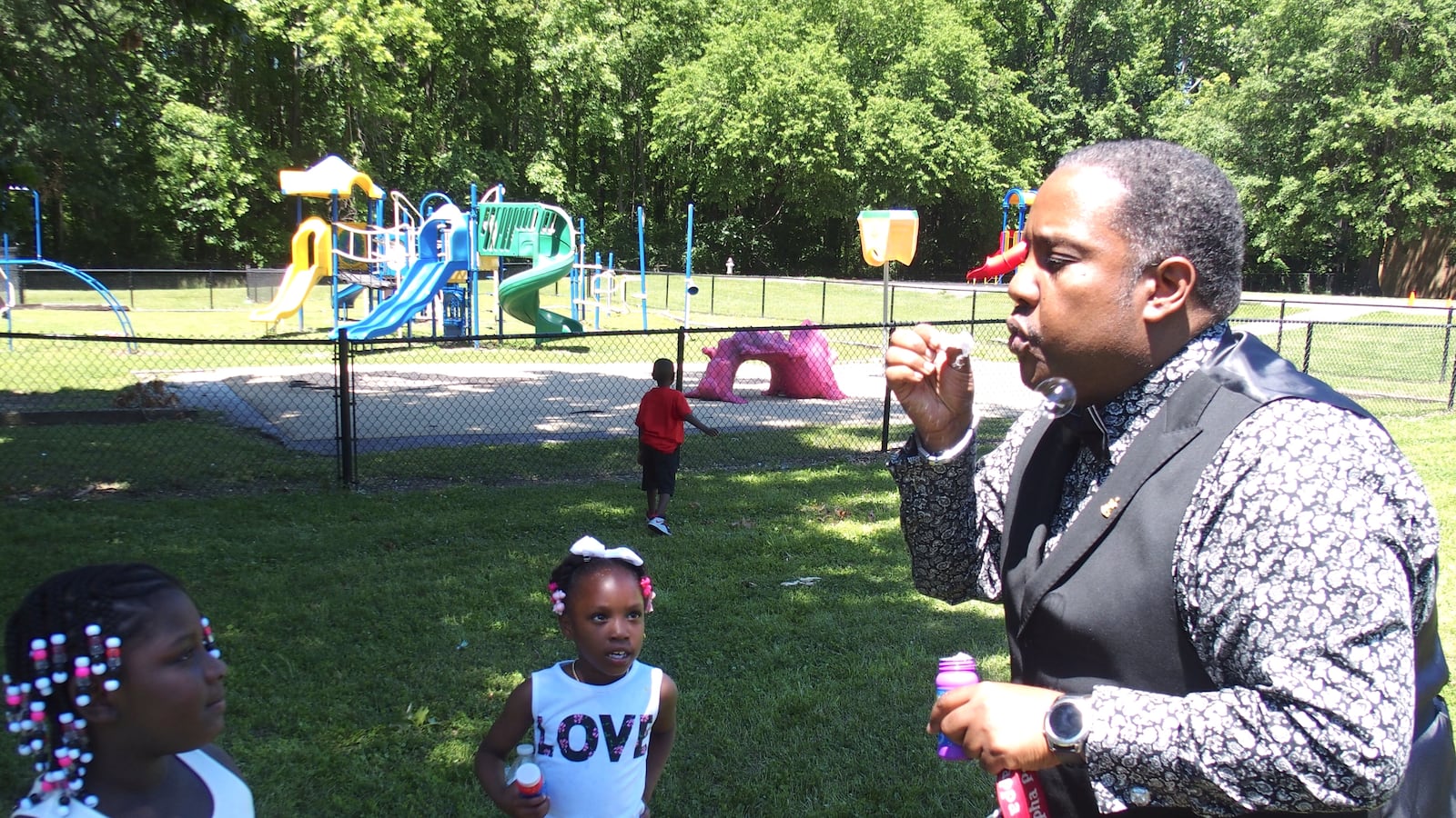 Principal Antonio Harvey shows kindergarteners how to blow bubbles during a graduation celebration at Hawkins Mill Elementary School in the Frayser community of Memphis.