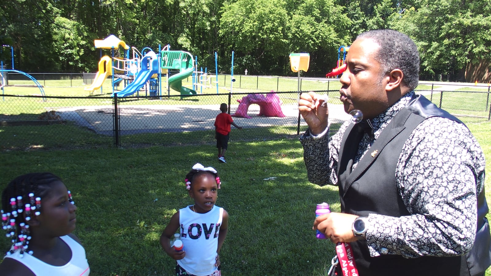 Principal Antonio Harvey shows kindergarteners how to blow bubbles during a graduation celebration at Hawkins Mill Elementary School in the Frayser community of Memphis.