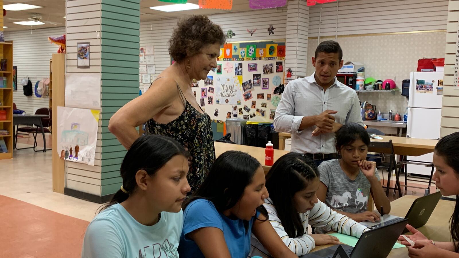 Students work on their writing at the El Futuro site of Mighty Writers with volunteer Sandee Mandel and Telemundo reporter Miguel Martinez-Valle.