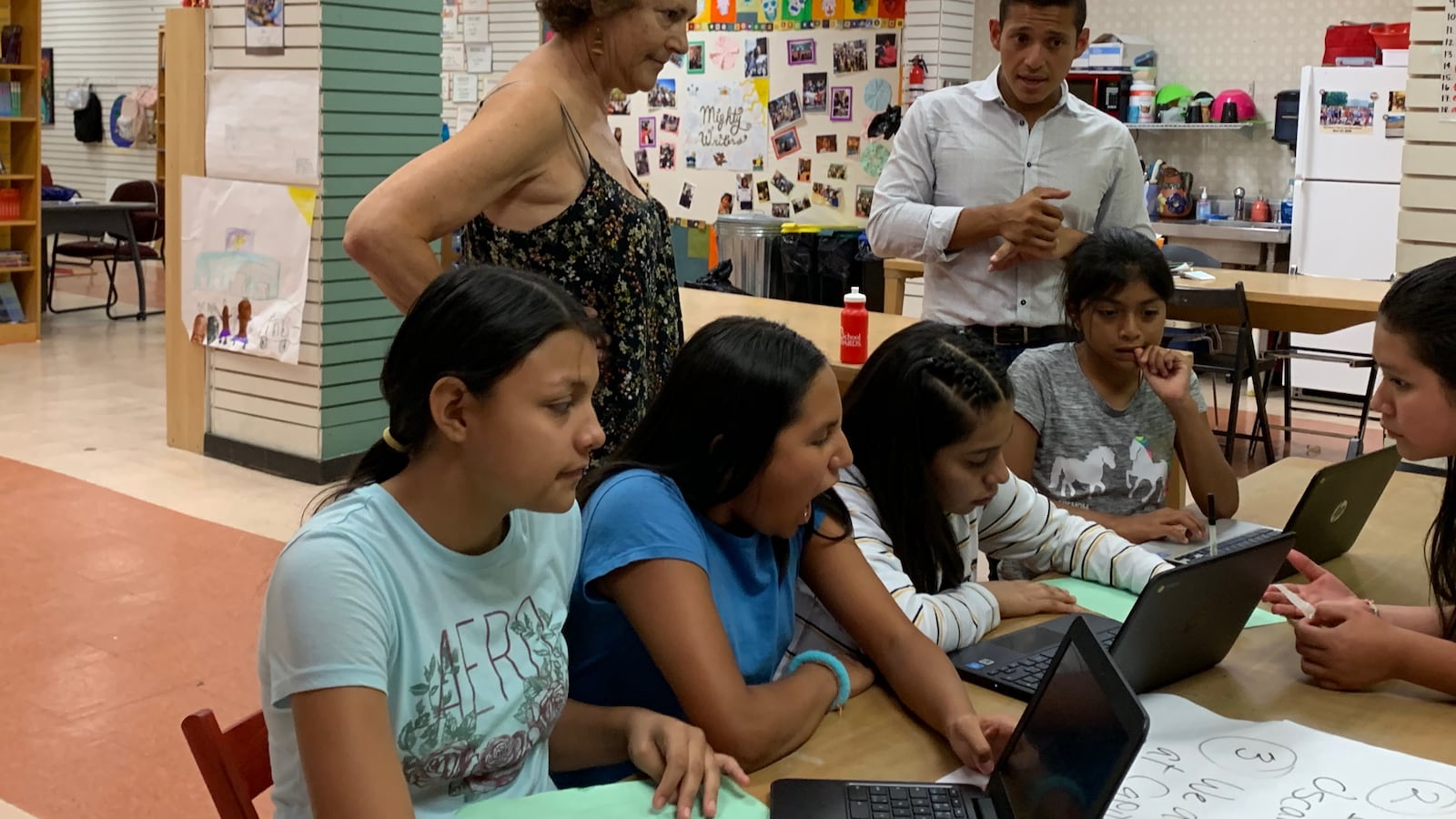 Students work on their writing at the El Futuro site of Mighty Writers with volunteer Sandee Mandel and Telemundo reporter Miguel Martinez-Valle.