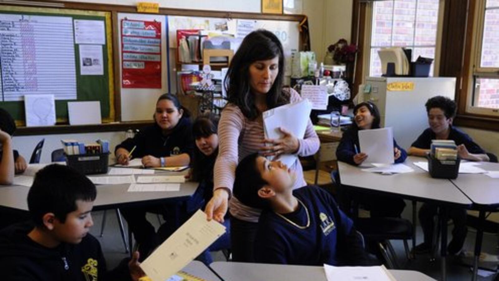 A teacher returns test scores to her class at Lake International School in Denver in 2012.