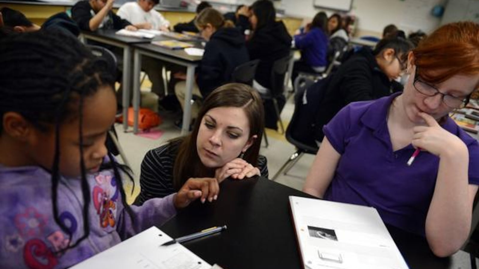 Sixth-grade science teacher Monica Wisniewski works with Pija Williams Terralee, left, and Myth Cubbison at Kearney Middle School in Commerce City. Kearney is in Adams County School District 14.