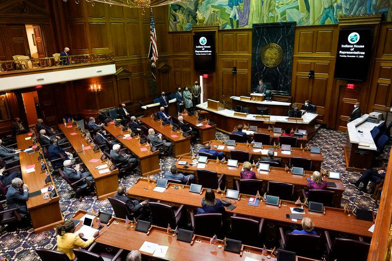 Legislators work at their desks in the Indiana Statehouse.